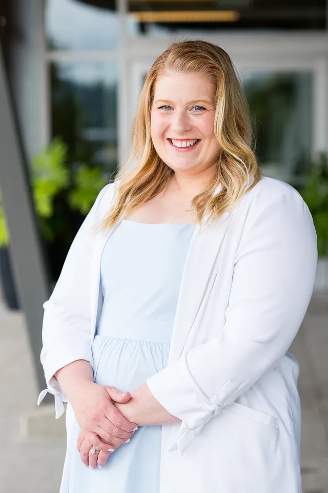 Jessica Morrison smiling, hands clasped, outdoors.